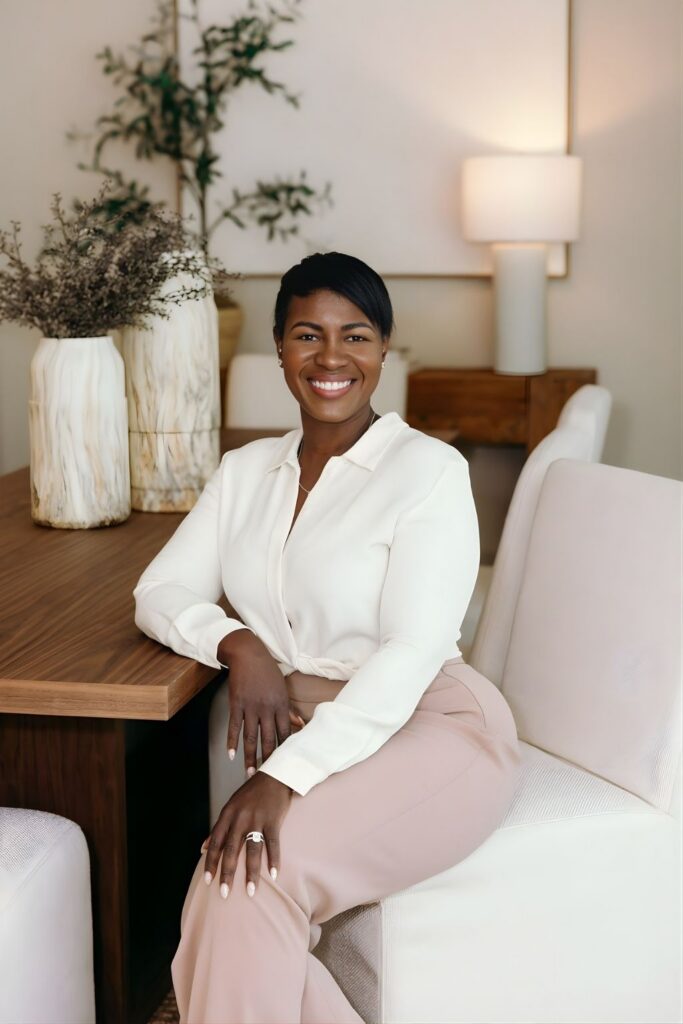 Philly Rodriguez, a professional Naples Realtor, smiling in a beautifully styled living room environment.