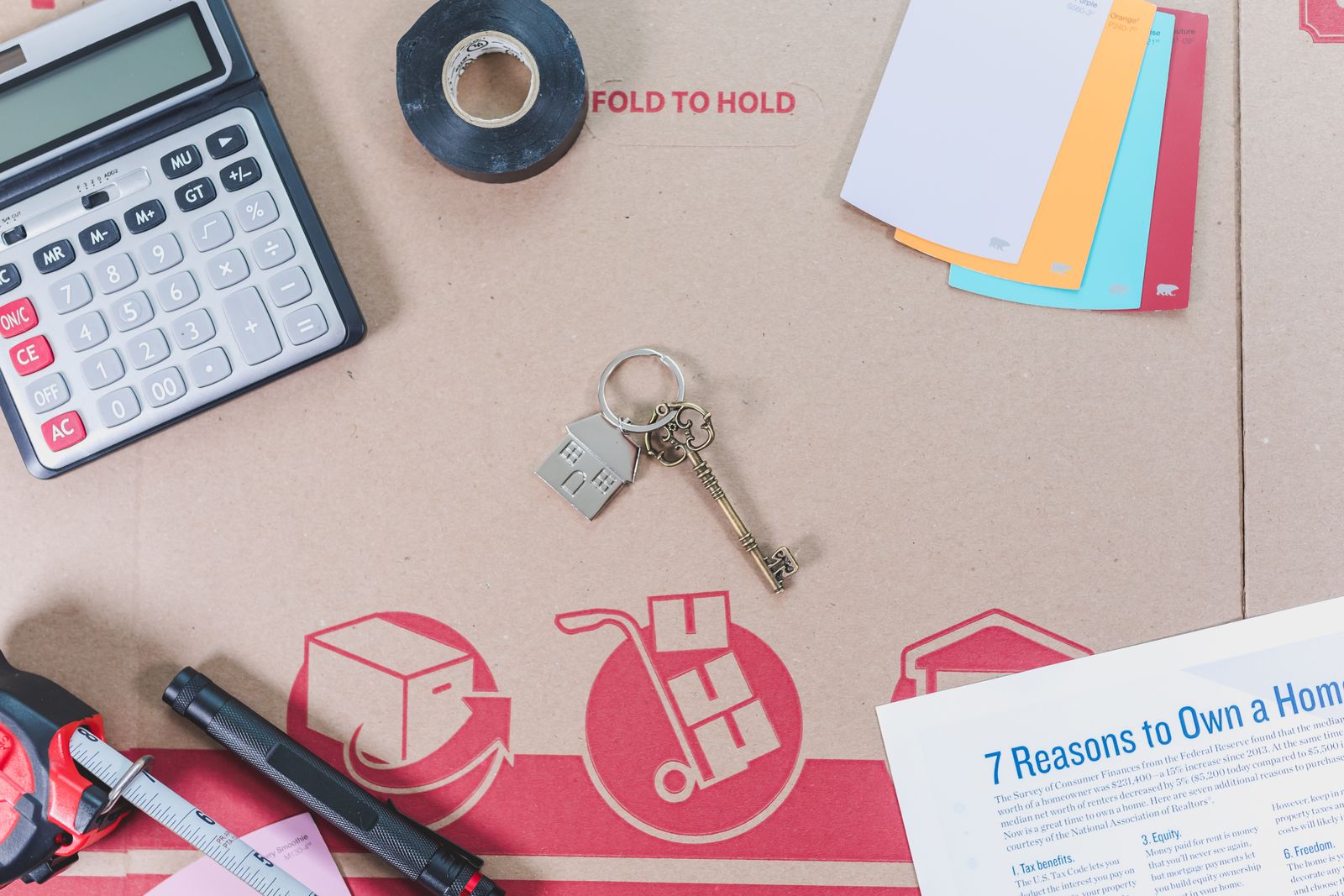 Calculator, house keys and home buying paperwork used to estimate closing costs on a Naples purchase
